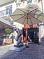 Statue and umbrella in front of entrance door