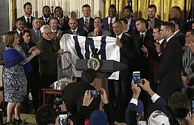 Cubs visit to the White House, Obama presented with 'W' flag (1) (cropped).jpg