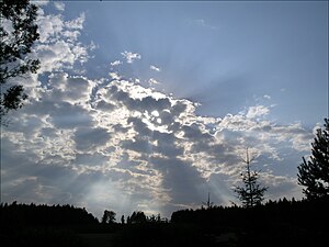 太陽を覆い隠し、隙間から光芒が差す不透明高積雲