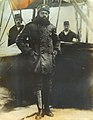 Ahmet Ali in flight suit with officers wearing a fez in the background.