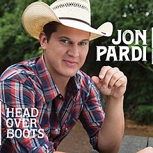 The cover features a man wearing a plaid shirt and cowboy hat, sitting on a picnic table in a forest park, with his left elbow resting on it.