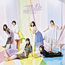 6 women pose with the large-size colorful cellophanes. The top of the cover shows the title "ごめんねFingers crossed" and the group's name "乃木坂46" in purple font.