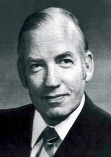 Black and white photo of Calcutt in a suit and tie