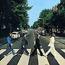 The cover of Abbey Road has no printed words. It is a photo of the Beatles, in side view, crossing the street in single file.