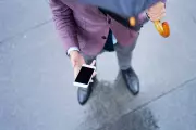 Person holding umbrella and looking down at cell phone