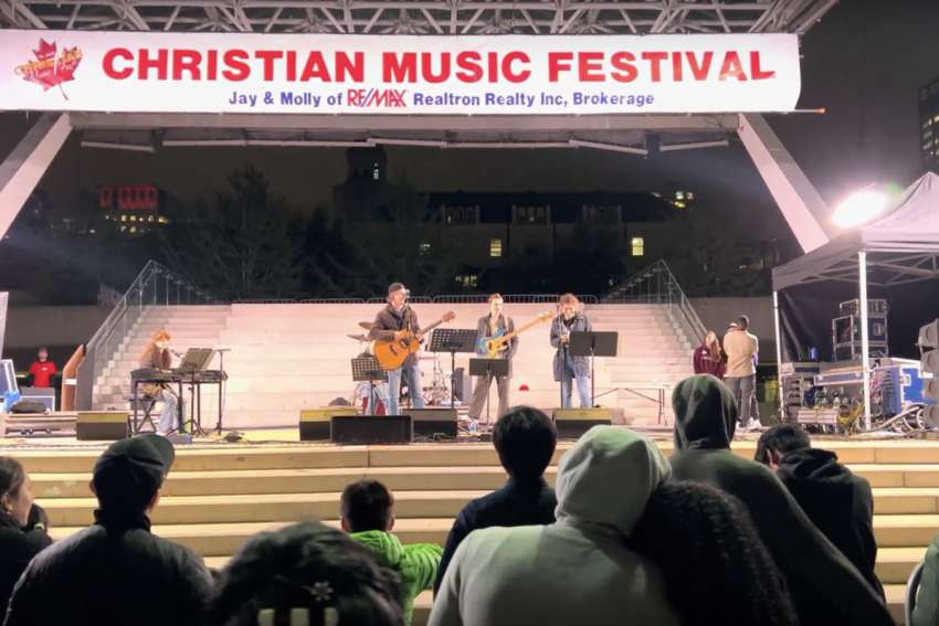 A shot from the front row of the audience during a live performance at 2023 Christian Music Festival in Nathan Phillips Square. 