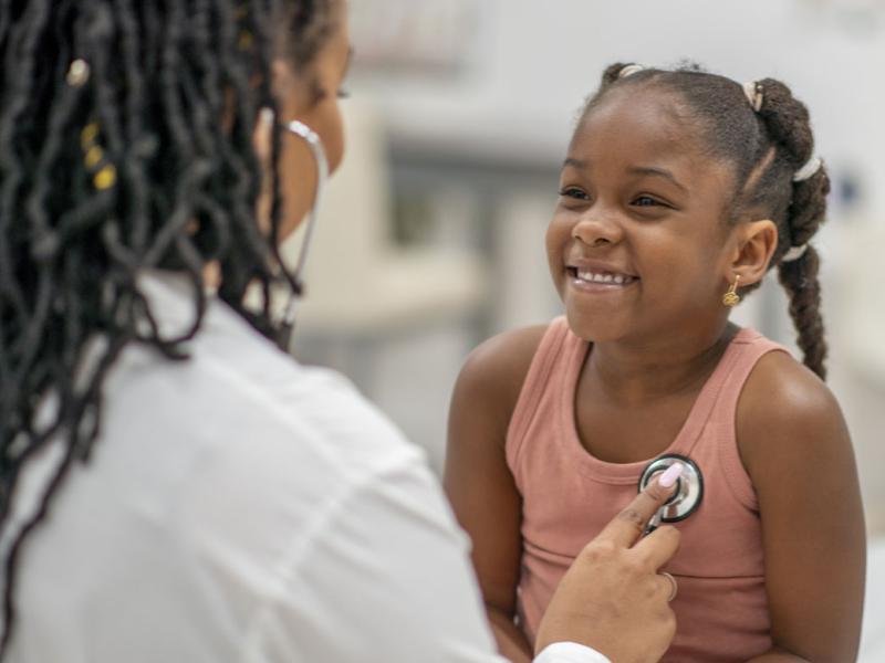 Doctor examining a smiling young patient