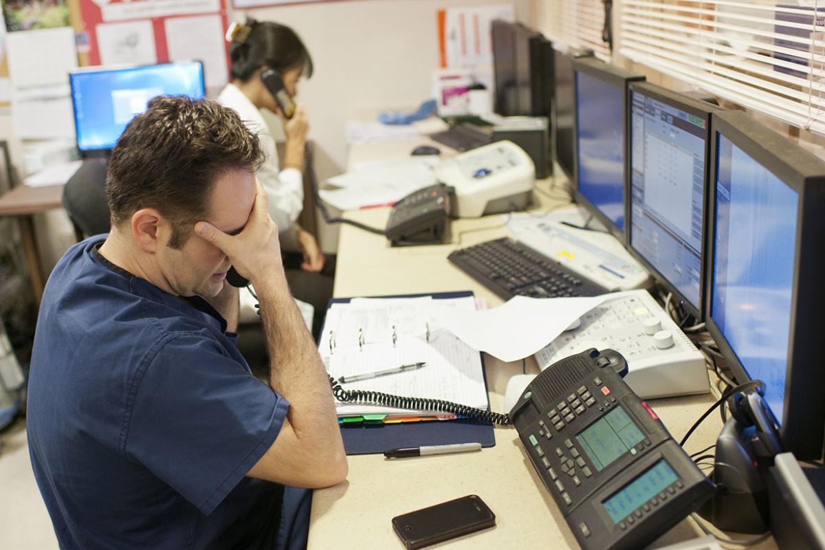 Stressed doctor talks on telephone