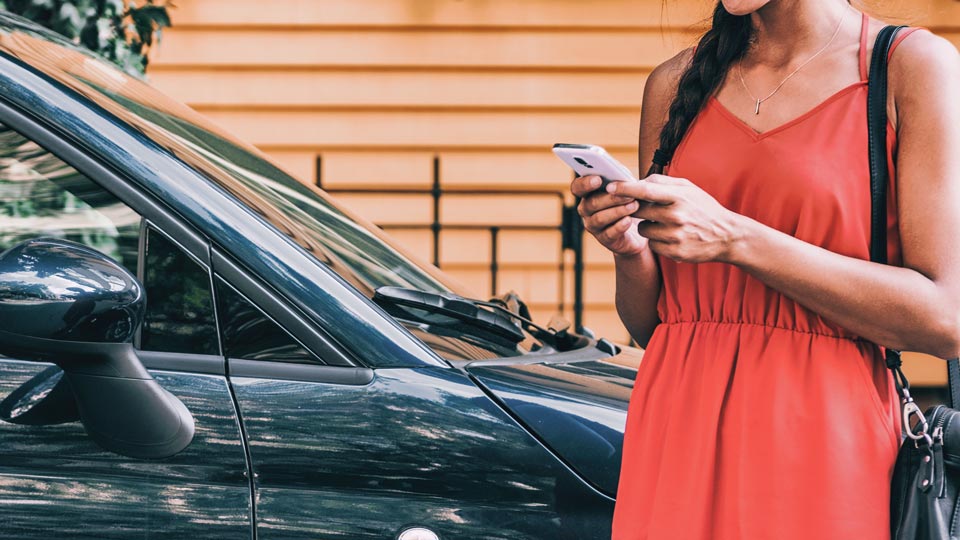 Donna che sblocca un'auto con un telefono