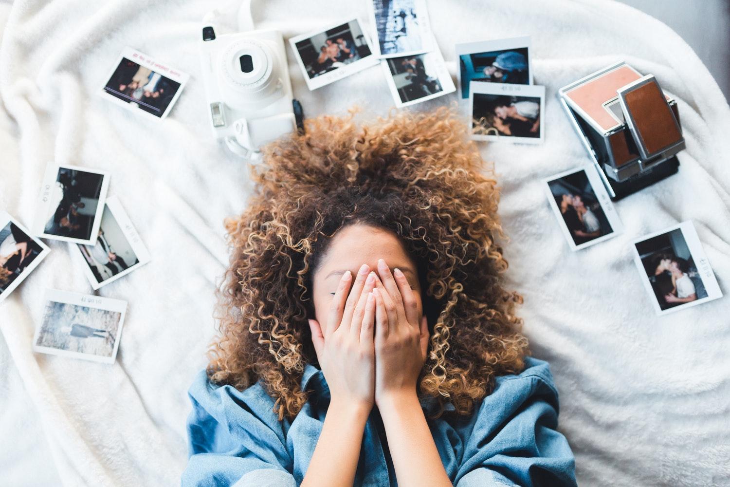 Mädchen liegt zwischen Fotos 