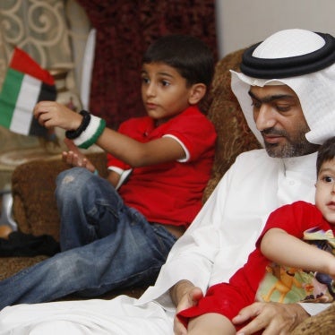 A man sits on a couch with two boys