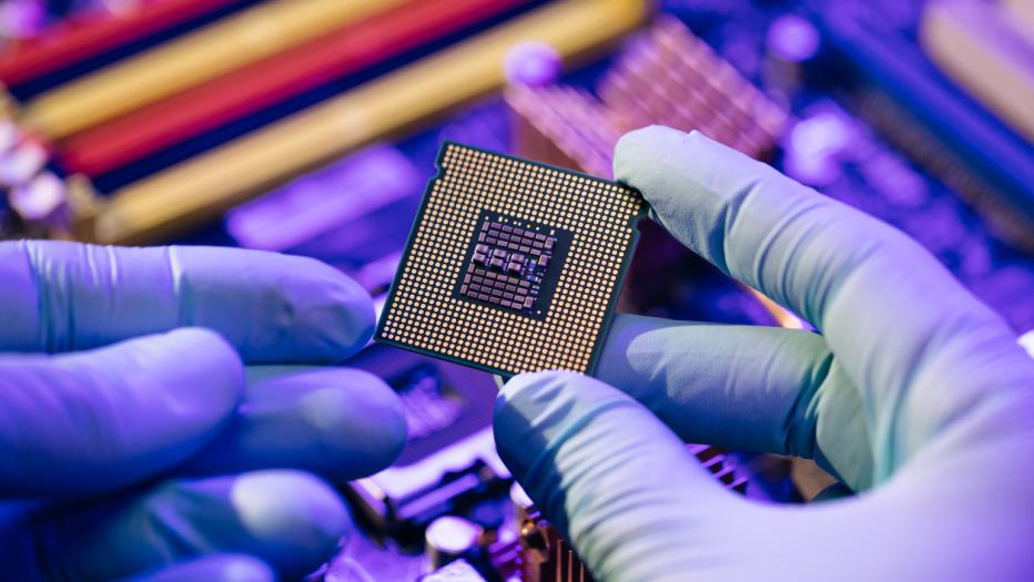 Laboratory technician holds a powerful processor in his hands. CPU computer processor shallow focus. CPU socket of the computer's motherboard. Concept of computer, motherboard, hardware and technology