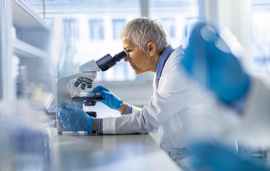 Chemist working on a microscope in laboratory