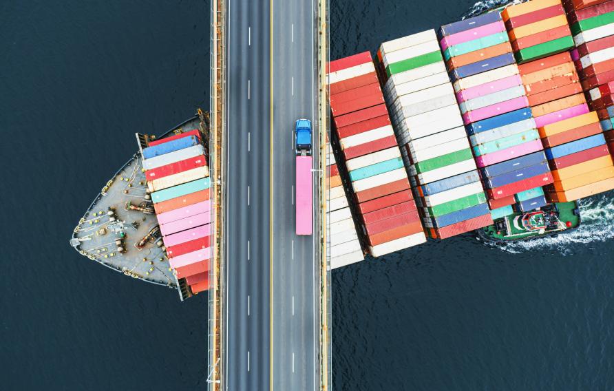 Shipping container sailing under a bridge