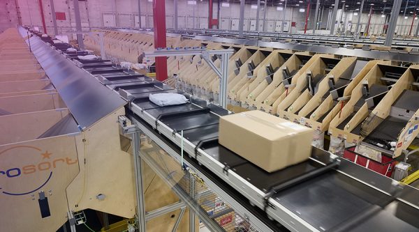 shipping boxes and packages moving on a conveyor belt in a Pitney Bowes ecommerce facility