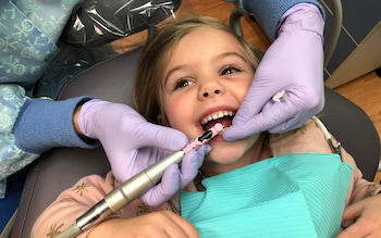 Little girl getting her teeth cleaned at the dentist