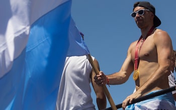 Argentine goalkeeper Emiliano Martinez celebrates on board a bus with a sign reading "World Champions" with supporters after winning the Qatar 2022 World Cup tournament as they tour through Buenos Aires' downtown on December 20, 2022