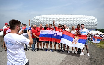 Slovenia and Serbia fans hold up their flags outside the stadium in Munich