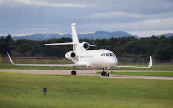 A white aircraft with three jet engines and upturned wingtips seen on the runway at Edinburgh Airport