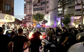 Onlookers gather in Beirut following an Israeli strike on a Hezbollah commander