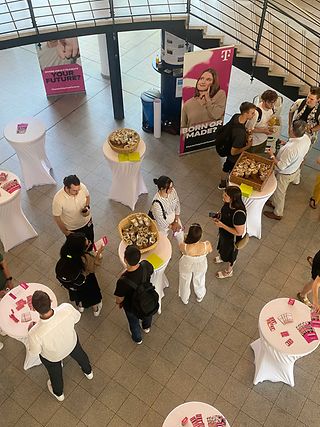 People stand at bar tables in a foyer