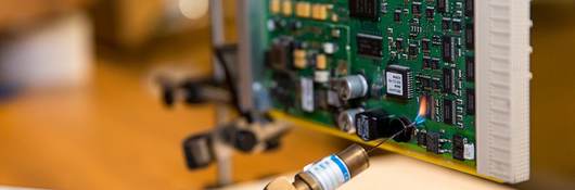 A worker fusing together parts of a motherboard. 