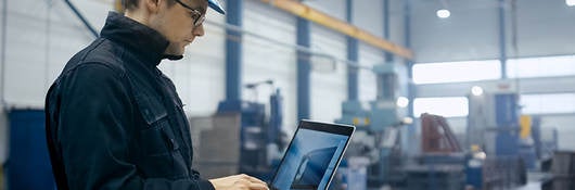 Worker in a hardhat using a laptop