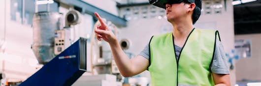 Manufacturing engineer wearing VR goggle headset in virtual reality simulation 