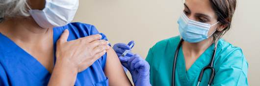 Nurse provides vaccine to elderly woman