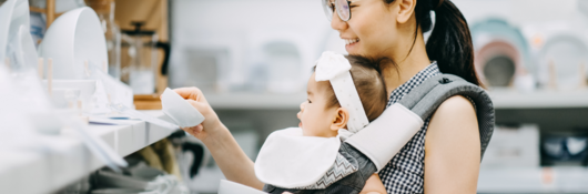 Woman shopping for dishes with her baby