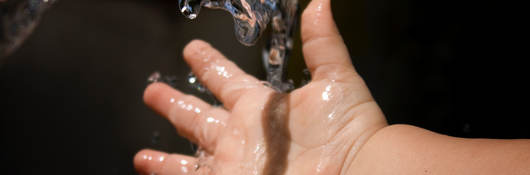 Baby holding hand under running water