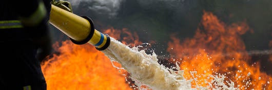 Firefighter using foam to put out a fire