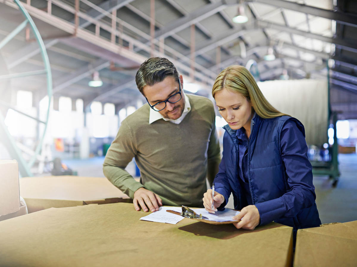 A Man and a woman look at something together in workplace