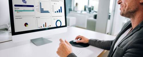 man at computer with data on screen