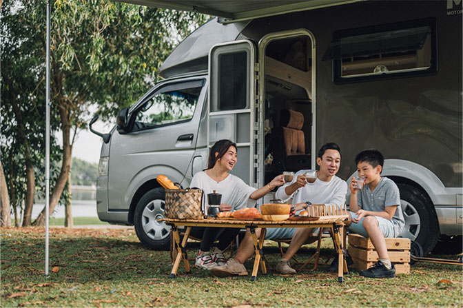 Family camping outside with an RV.