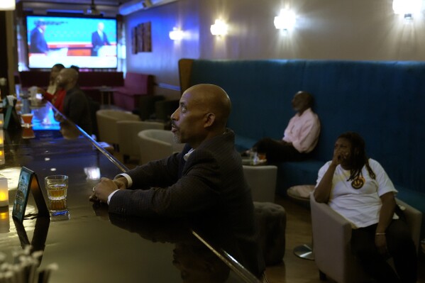 Reginald Marsh, owner of the M Lounge in the South Loop neighborhood of Chicago, watches with patrons the Presidential Debate Thursday, June 27, 2024. Marsh says he has no one issue this election cycle, "I just believe Trump is dangerous for this country." (AP Photo/Charles Rex Arbogast)