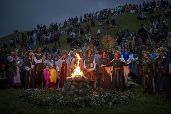 People wear traditional Lithuanian village-styled clothes as they celebrate Saint John's Day and the summer solstice in the small town of Kernave, some 35km (22 miles) northwest of the capital, Vilnius, Lithuania, Sunday, June 23, 2024. (AP Photo/Mindaugas Kulbis)