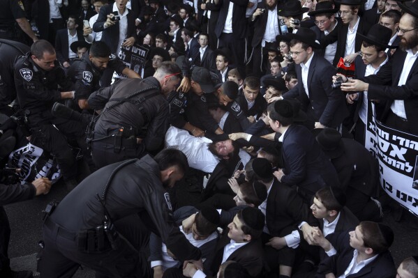 Israeli police officers disperse Ultra-Orthodox Jews blocking a highway during a protest against army recruitment in Bnei Brak, Israel, Thursday, June 27, 2024. (AP Photo/Oded Balilty)