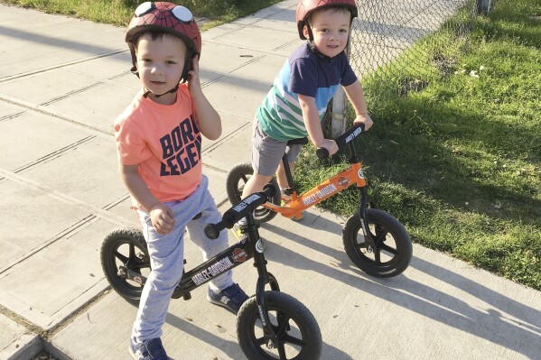 Jackson, left, and Owen Pezalla, both 4, appear on balance bicycles in Seattle on July 1, 2017. Experts recommend starting with those so-called balance bikes at a younger-than-expected age, possibly even less than a year old. (Annie Pezalla via AP)