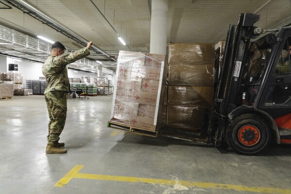 FILE - In this image provided by the U.S. Army, paratroopers assigned to the 82nd Airborne Division, assist with unloading humanitarian goods in support of the United States Agency for International Development (USAID) in preparation of potential evacuees from Ukraine at the G2A Arena in Jasionka, Poland, on Feb. 25, 2022. Charitable giving dropped 2.1% in 2023 after inflation, according to the most recent Giving USA report, the key findings of which were released Tuesday, June 25, 2024. (Sgt. Robert Whitlow/U.S. Army via AP, File)
