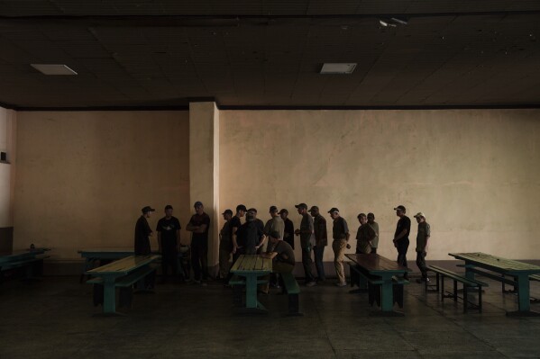 Prisoners wait in line to have lunch in a prison, in the Dnipropetrovsk region, Ukraine, Friday, June 21, 2024. Ukraine is expanding its military recruiting to cope with battlefield shortages more than two years into fighting Russia’s full-scale invasion. (AP Photo/Evgeniy Maloletka)