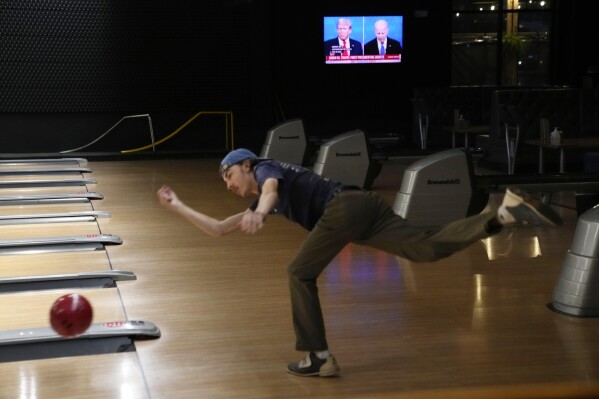 Liam Van Rosenberg bowls during the presidential debate between President Joe Biden and Republican presidential candidate former President Donald Trump, during a watch party at Broadway Bowl, Thursday, June 27, 2024, in South Portland, Maine. (AP Photo/Robert F. Bukaty)