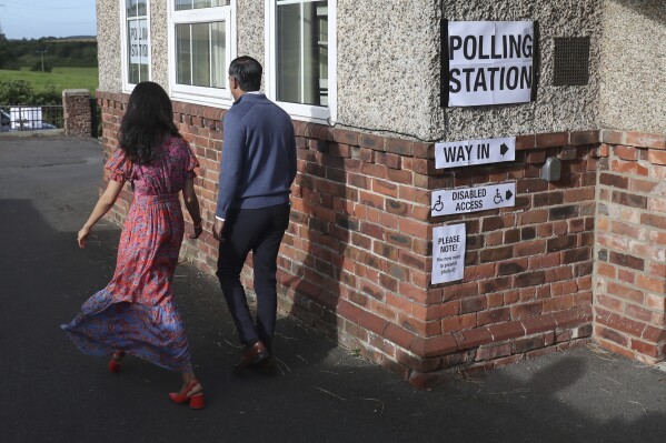 Britain's Prime Minister Rishi Sunak and his wife Akshata Murty walk from a polling station after voting near Richmond, North Yorkshire, England, Thursday, July 4, 2024. Britain goes to the polls Thursday after Prime Minister Rishi Sunak called a general election. (AP Photo/Scott Heppell )
