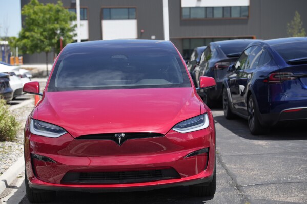 FILE - Unsold 2023 Model X sports-utility vehicles sit at a Tesla dealership, June 18, 2023, in Littleton, Colo. Tesla, the top selling electric vehicle maker in the world, is expected to report a second straight quarter of declining deliveries on Tuesday, July 2, 2024.(AP Photo/David Zalubowski)