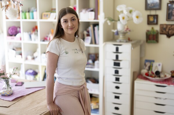 Amea Wadsworth poses for a portrait at her home, Friday, April 19, 2024, in San Diego. Wadsworth, who moved back home after graduating college, wanted to use her first full-time job as a chance to save, and a moment to take a hard look at her spending activity. (AP Photo/Gregory Bull)