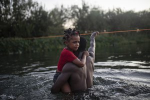 Haitian migrants wade across the Rio Grande from Del Rio, Texas, to return to Ciudad Acuña, Mexico, Sunday, Sept. 19, 2021, to avoid deportation to Haiti from the U.S. The U.S. is flying Haitians camped in a Texas border town back to their homeland and blocking others from crossing the border from Mexico