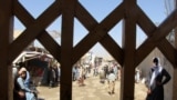 People wait to cross into Pakistan at the Spin Boldak border crossing in Afghanistan on July 22.<br />
<br />
After a nine-month closure that incited violent protests by angry residents and traders, Islamabad on July 21 announced that it will reopen the Spin Boldak border crossing point in Chaman.