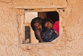 A child and mother peer through a window in Alsabaat community, Kassala state.