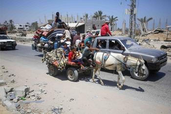 Palestinian families flee with their possessions following the latest evacuation order by the Israeli army.