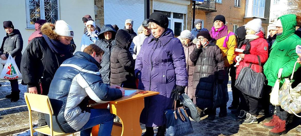 Women fleeing the combat zones of Donetsk and Luhansk oblasts stand in line to receive humanitarian aid. (file)